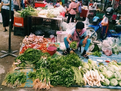 A vegetable vendor in northern Thailand sells an assortment of colorful greens, at an open air market